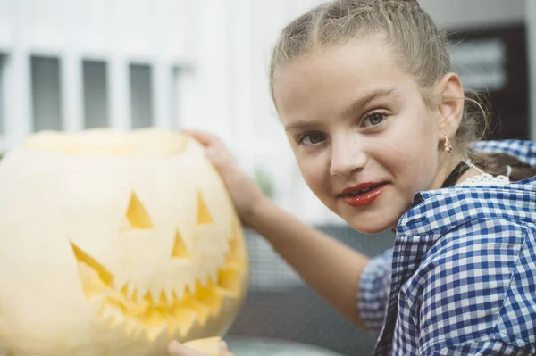 Menina esculpindo abóbora Halloween ao ar livre . — Fotografia de Stock