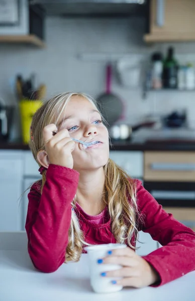 Little girl eating a healthy yoghurt breakfast — Stock Photo, Image