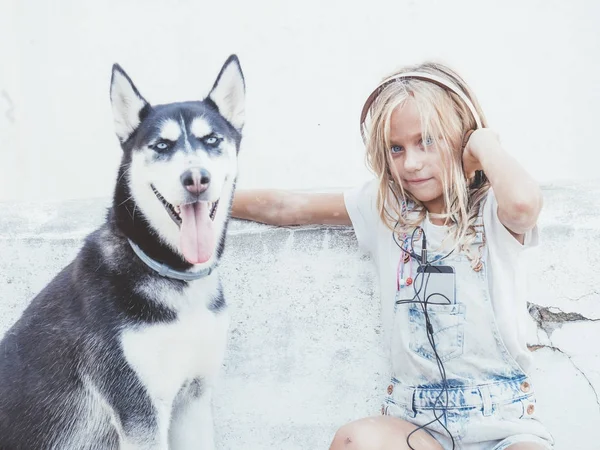 Mooi blond meisje vormt met huisdier Siberische Husky — Stockfoto