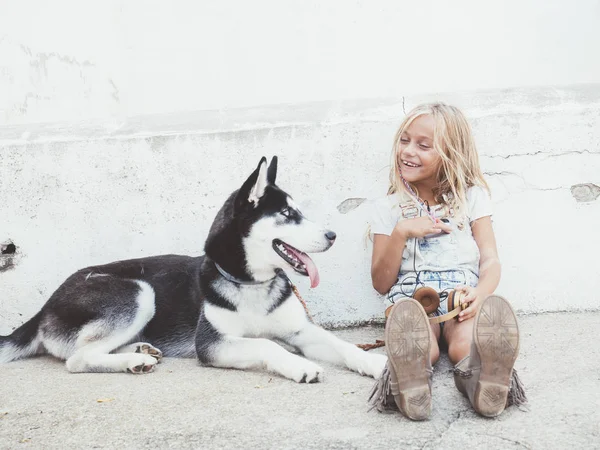 Mooi blond meisje vormt met huisdier Siberische Husky — Stockfoto