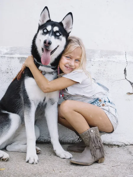 Mooi blond meisje vormt met huisdier Siberische Husky — Stockfoto