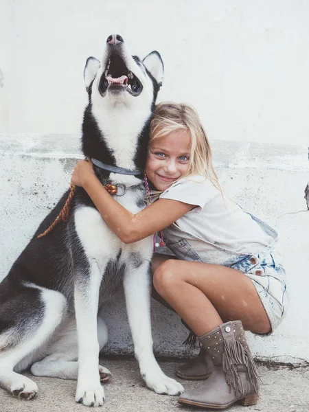 Mooi blond meisje vormt met huisdier Siberische Husky — Stockfoto