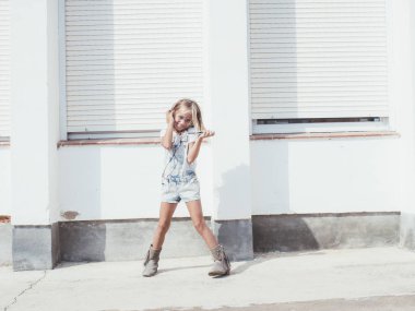 Küçük güzel kız telefonu sahiptir. O kulaklıklar. 