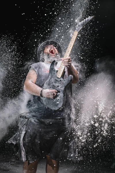 Homem com a guitarra entre o pó de giz e fumaça — Fotografia de Stock