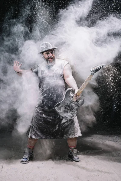 Hombre con la guitarra entre polvo de tiza y humo — Foto de Stock