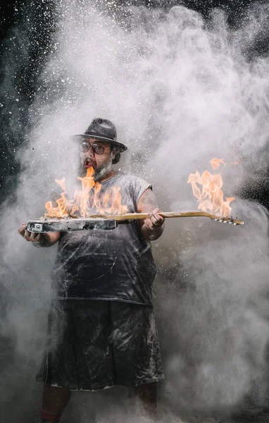 人用吉他与火在白垩和烟尘土之间 — 图库照片