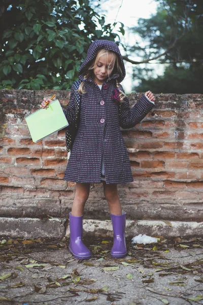 Маленька дівчинка з блокнотом на відкритому повітрі — стокове фото