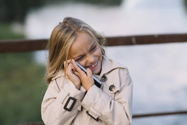 Маленька дівчинка з смартфоном на відкритому повітрі — стокове фото