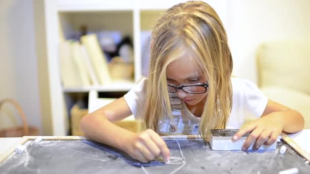 Маленькая девочка пишет на доске для копирования — стоковое видео