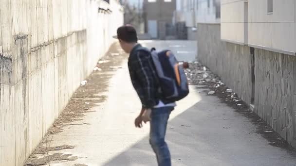 Joven con mochila y monopatín — Vídeos de Stock