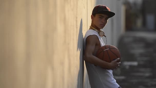 Joven sosteniendo una pelota de baloncesto — Vídeos de Stock