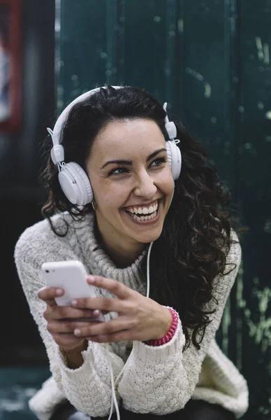 Happy girl smiling he listens to music with white earphones
