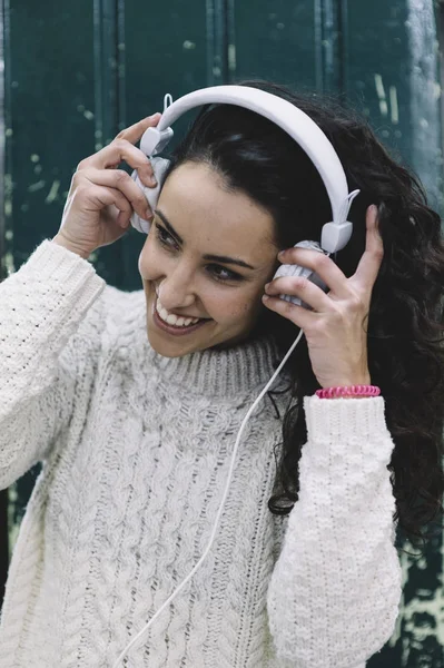 Chica feliz sonriendo él escucha música con auriculares blancos —  Fotos de Stock