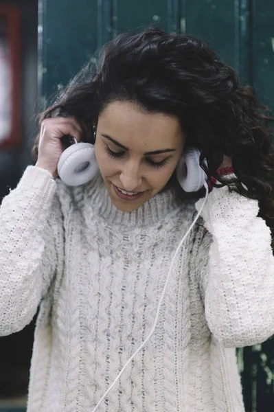 Gadis bahagia tersenyum dia mendengarkan musik dengan earphone putih — Stok Foto