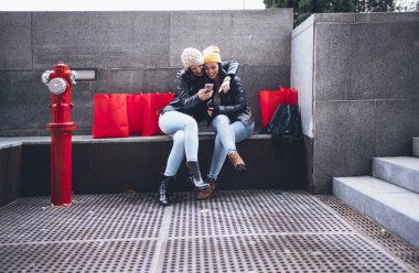 İki arkadaş alışveriş caddesi smartphone ile