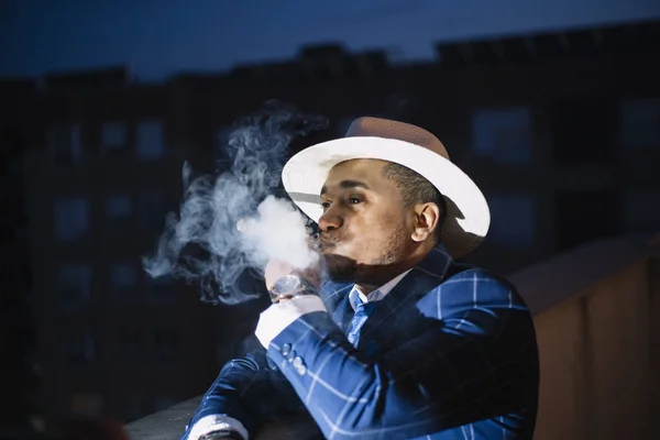 man smoking whit hat
