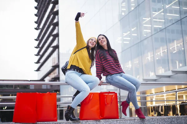 Dwie kobiety przyjaciół, biorąc selfie w ulicy po zakupy — Zdjęcie stockowe