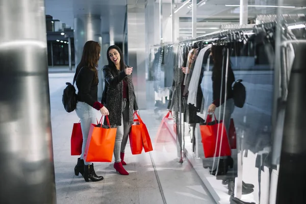 Vitrin şehir bakarak alışveriş iki genç kadın