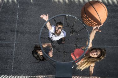 Üç arkadaş birlikte basketbol oynarken