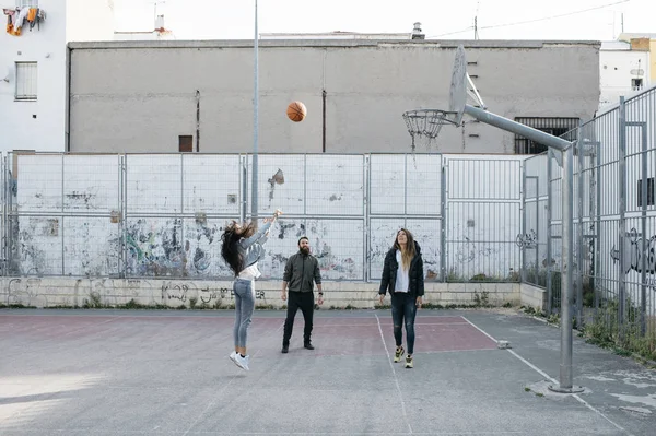 Three friends playing basketball together