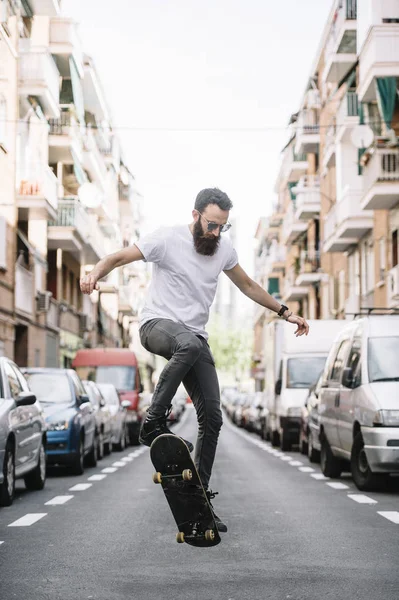 Mladý skejťák triky s jeho skateboard na ulici — Stock fotografie