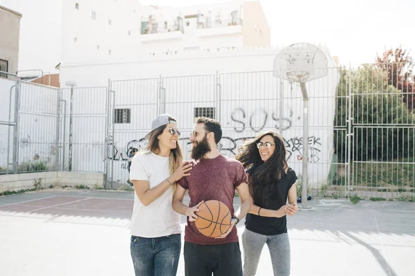 Three friends playing basketball together