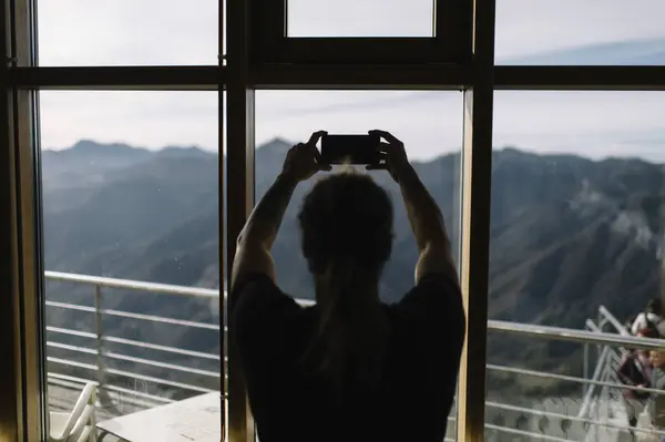 Homem com smartphone olhando para as montanhas — Fotografia de Stock