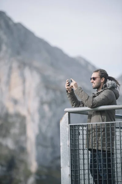 Young man with smartphone in the mountain — Stock Photo, Image