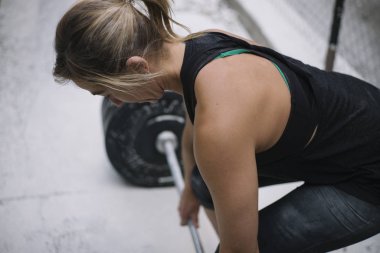 Sokakta ağırlıkları ile çalışan kadın