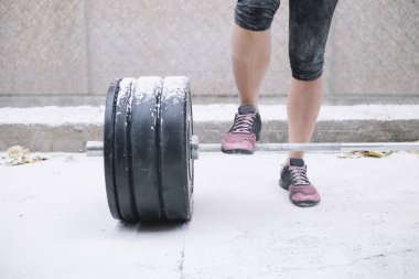 Sokakta ağırlıkları ile çalışan kadın