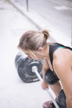 Sokakta ağırlıkları ile çalışan kadın