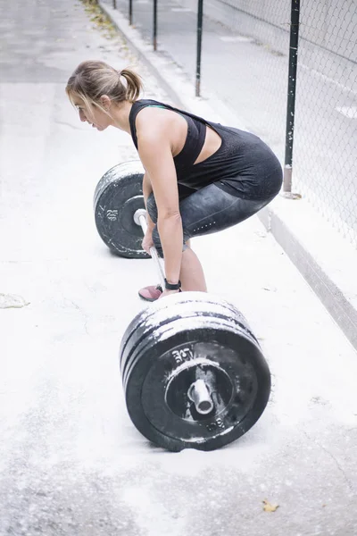 Sokakta ağırlıkları ile çalışan kadın