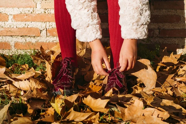 Manos de niña abrochando zapatos rojos —  Fotos de Stock