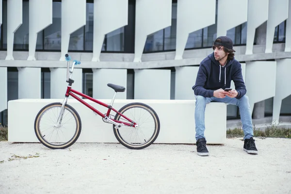 Male BMX rider on street with phone