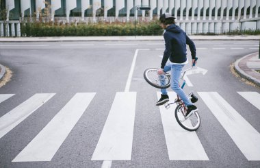 Genç adam BMX bisikletiyle pratik yapıyor..