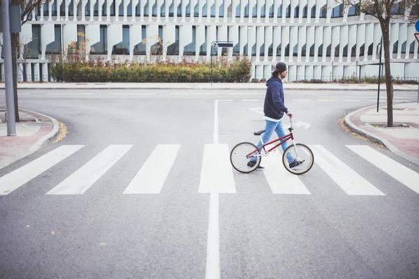 Masculino BMX cavaleiro no rua caminhando no zebra cruzamento — Fotografia de Stock