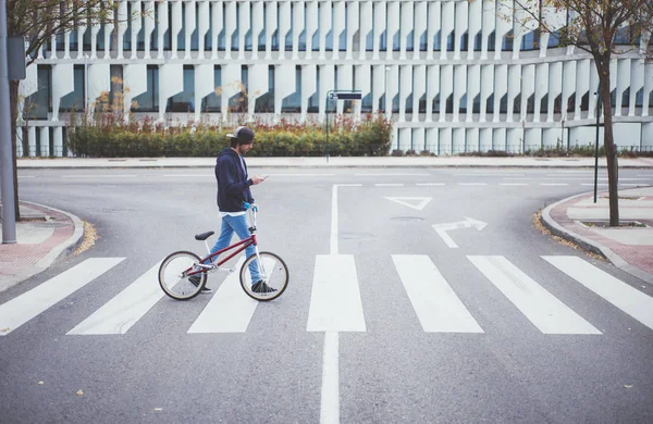 Masculino BMX cavaleiro na rua com telefone — Fotografia de Stock