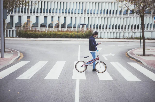 Masculino BMX cavaleiro na rua com telefone — Fotografia de Stock