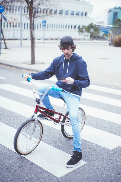 Pilota BMX maschio in strada con telefono — Foto Stock