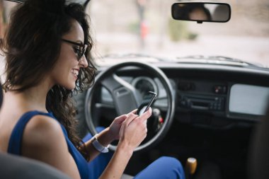 Cep telefonu arabada kullanan güzel genç kadın.