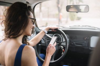 Cep telefonu arabada kullanan güzel genç kadın.