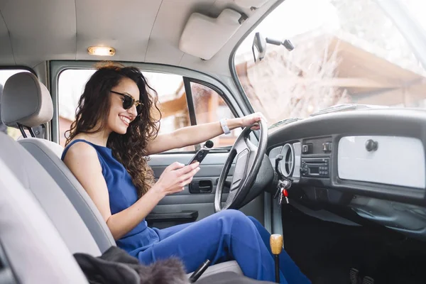 Krásná mladá žena pomocí svého mobilního telefonu v autě. — Stock fotografie