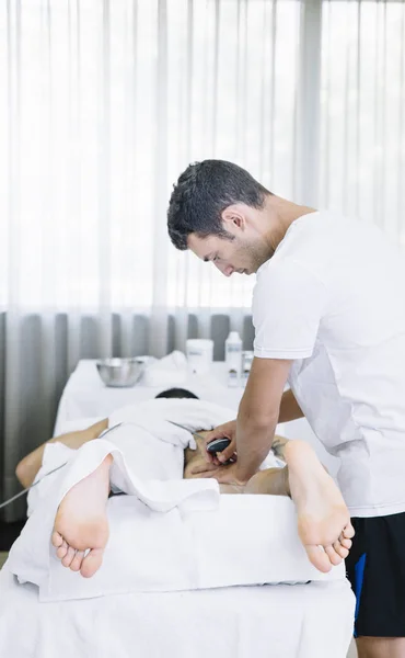 El fisioterapeuta que trata a un hombre usando equipos para la radio —  Fotos de Stock