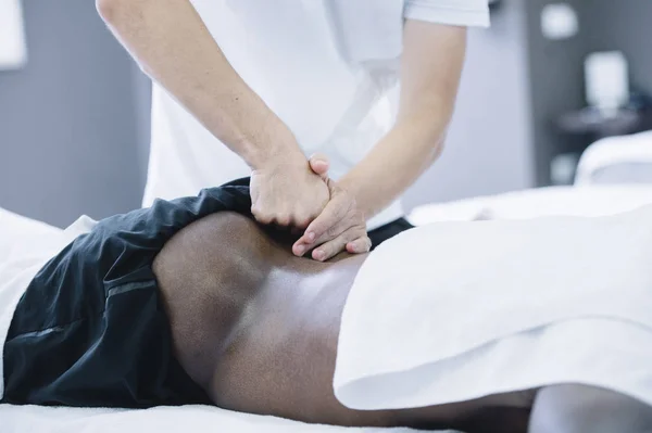 The physiotherapist treating a man using equipment for radio the — Stock Photo, Image