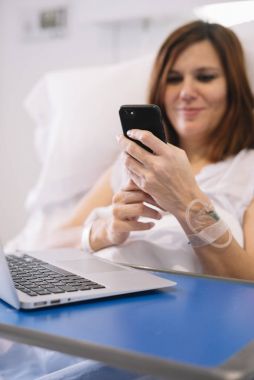 Smartphone ve dizüstü hastane ile hasta kadın