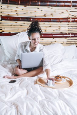 Telefonu ve laptop yatakta güzel kadın