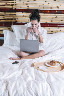 Telefonu ve laptop yatakta güzel kadın