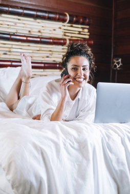 Telefonu ve laptop yatakta güzel kadın