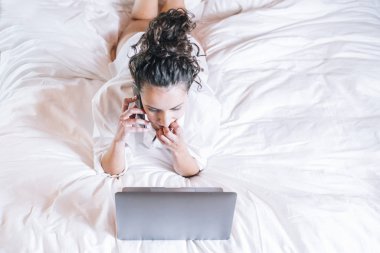Telefonu ve laptop yatakta güzel kadın