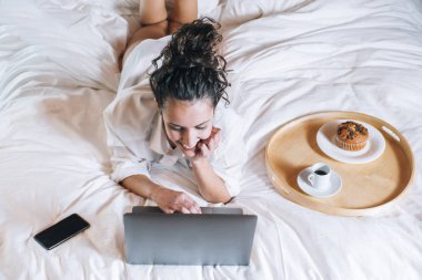 Telefonu ve laptop yatakta güzel kadın